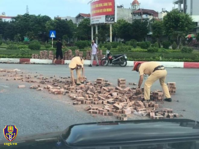 CSGT dọn gạch rơi vãi trên đường giữa trời hè oi bức